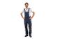 Een man in een donkerblauwe overall en witte T-shirt