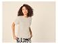 Vrouw in een beige T-shirt met korte mouwen en zwart-wit gestreepte broek.
