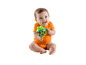 Een baby in een oranje pakje speelt met een groene kikker-ratel.