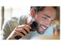 Een man trimmet zijn baard met een Philips trimmer.