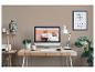 Bureau met computer, lamp, planten en decoraties, inclusief een Boeddhabeeld en ingelijste tekst 'DON'T GROW UP IT'S A TRAP'.