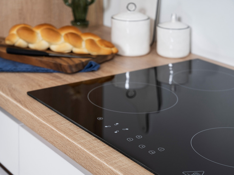 Een zwarte inductiekookplaat met drie kookzones.