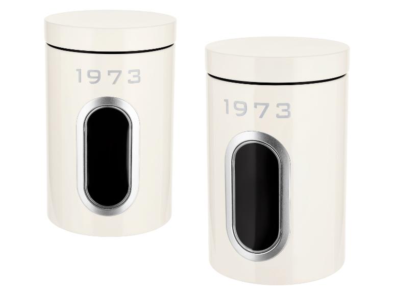 Twee crèmekleurige bussen met de tekst '1973' en een venster voor inhoud.