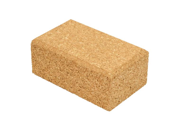 Een rechthoekig kurken yogablok, lichtbruin met een gestructureerd oppervlak, geïsoleerd op wit.