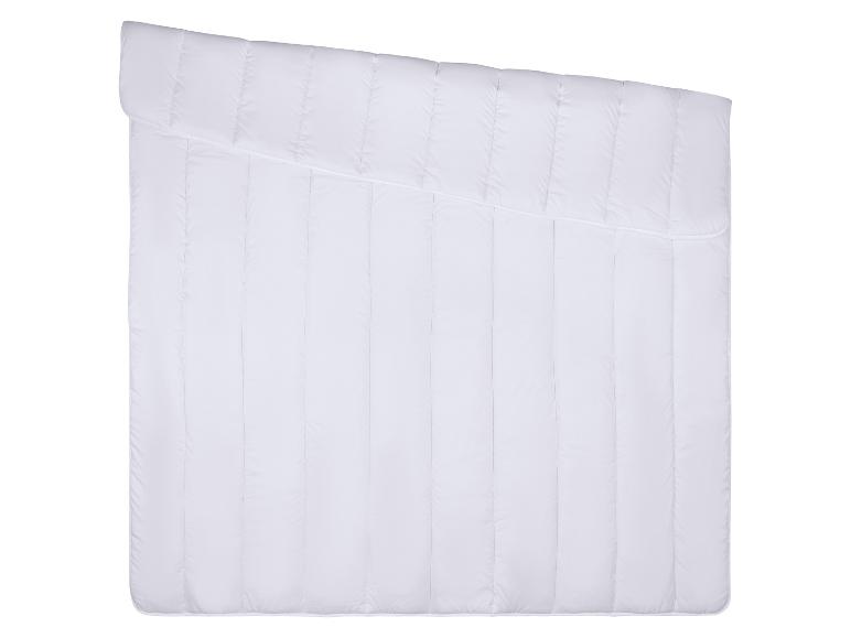 Wit gewatteerd dekbed met verticale stiksels en een diagonale naad