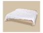 Wit gewatteerd dekbed op een houten bed met beige lakens.