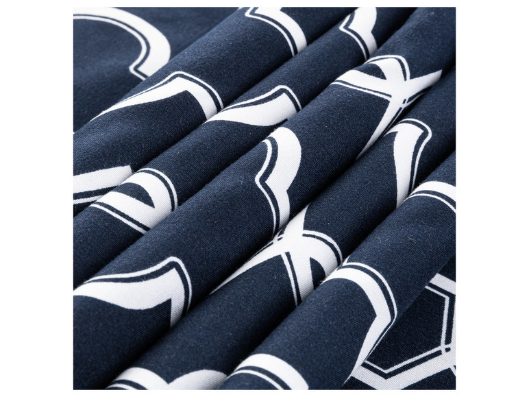 Nauw detail van een donkerblauwe stof met witte geometrische patronen.