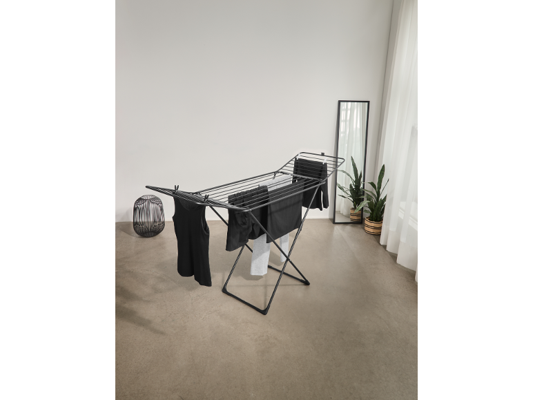 Zwart wasrek met donkere kleding in een lichte kamer.