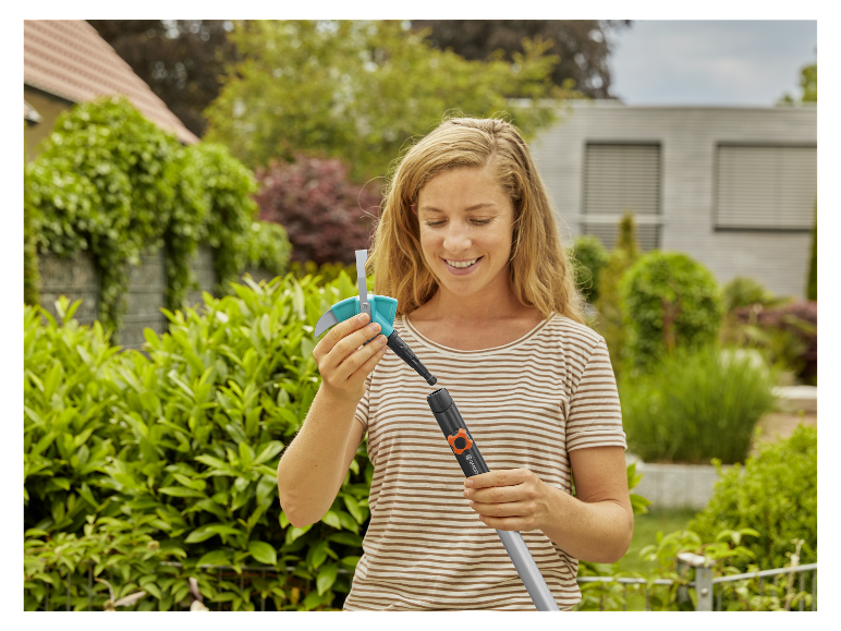 Een vrouw zet een Gardena heggenschaar en -trimmer in elkaar.