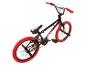 Zwarte BMX-fiets met rode banden en handvatten.