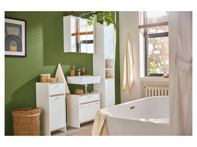 Badkamer met een witte wastafel, spiegelkast, twee witte kasten en een bad.