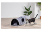 Een kat speelt met een grijs kattenhol met een borstel.