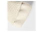 Close-up van een beige gebreide trui met fleece voering.