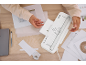 Persoon die papier lamineert en snijdt met een witte lamineermachine op een houten tafel.