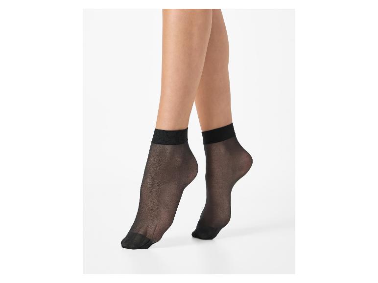 Vrouwenbenen met zwarte, transparante sokken op een witte achtergrond.