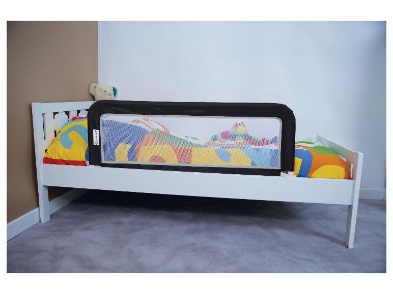 Wit kinderbed met zwarte Safety 1st bedhek en kleurrijk beddengoed.