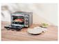 SilverCrest mini-oven met pizza erin, naast een bord en slakom.