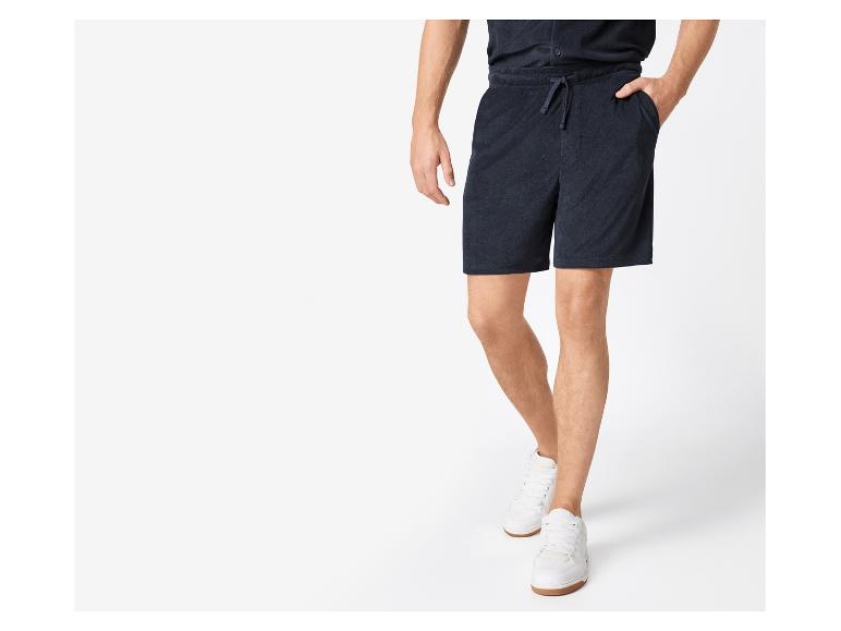 Herenshorts en witte sneakers.