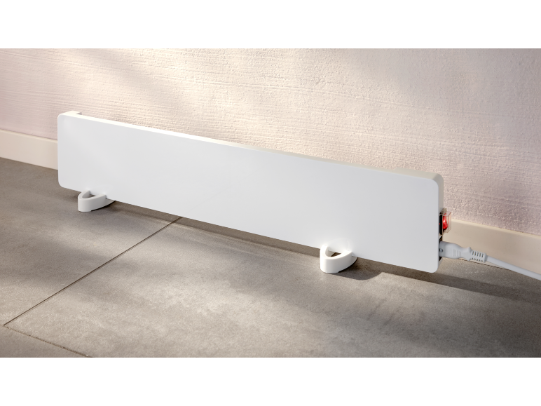 Witte elektrische convectorverwarming op de vloer met een rode aan/uit-schakelaar.