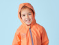 Een kind in een oranje regenjas met capuchon.