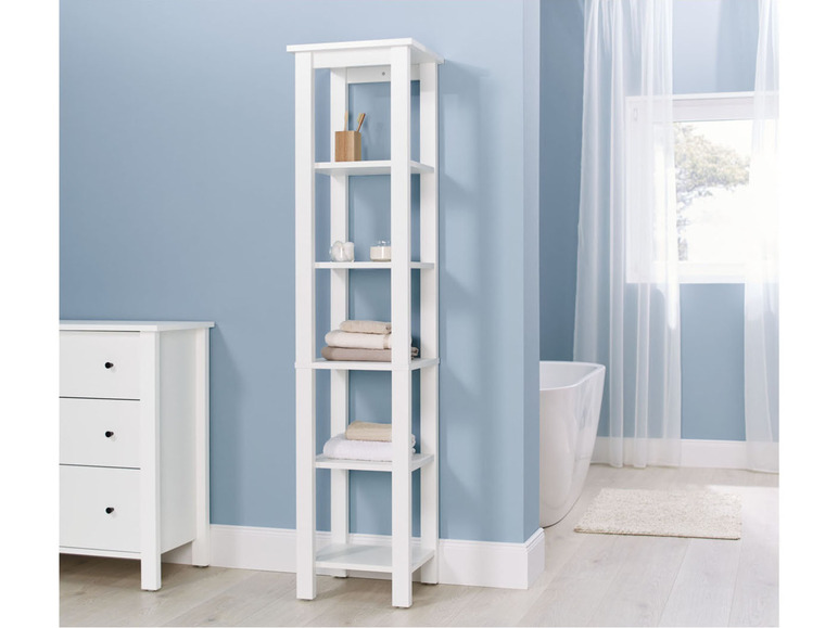 Een witte badkamerkast met vijf planken, gevuld met handdoeken en andere badkamerbenodigdheden.