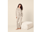 Vrouw in een comfortabel beige tweedelig huispak.