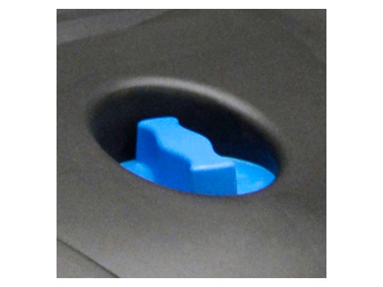 Een blauwe knop in een grijze plastic console.