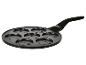 Zwarte pannenkoekenpan met zeven ronde vormen met smileygezichten.