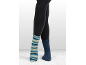 Benen in donkere leggings, één voet in een gestreepte sok, de andere in een effen blauwe sok.