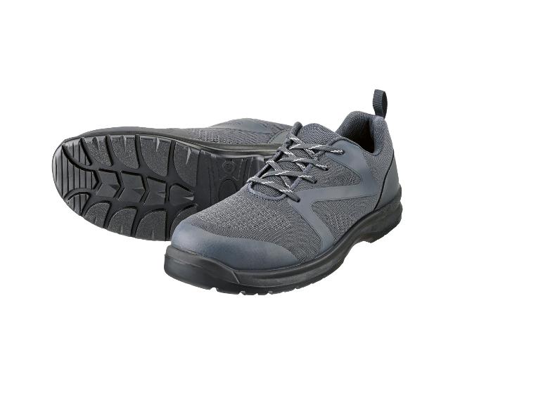 Een paar grijze veterschoenen, één schoen ligt op zijn zij en toont de zool.