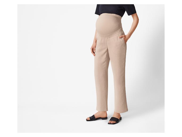 Beige zwangerschapsbroek en zwarte sandalen.