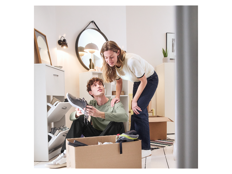 Jong stel pakt verhuisdozen uit, past schoenen.
