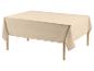 Lichtbeige tafelkleed op een houten tafel met houten poten.