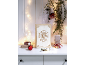 Kerstdecoratie met lichtslingers, een houten doos met boodschap, ornamenten en cadeaus op een witte tafel.