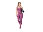 Vrouw in paarse sporttop en legging, met een blauwe yogamat over haar schouder
