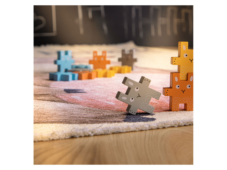 Houten puzzelstukken met dierenmotieven op een vloerkleed.