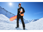 Man in snowboardjas en -broek, helm, bril, met snowboard tegen besneeuwde bergachtergrond.