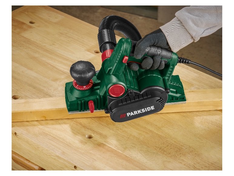 Een timmerman gebruikt een Parkside schaafmachine om hout te bewerken.