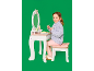 Lachend meisje speelt met een houten speelgoedkaptafel en krukje, doet alsof ze make-up opdoet.