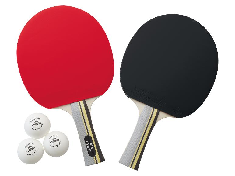 Twee Crivit pingpongbatjes, rood en zwart, met drie balletjes.