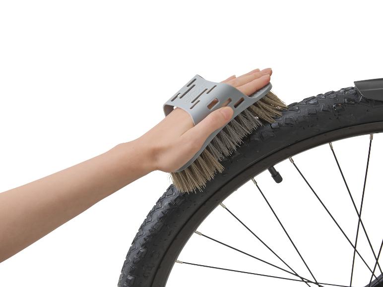 Fietswiel schoonmaken met een borstel.
