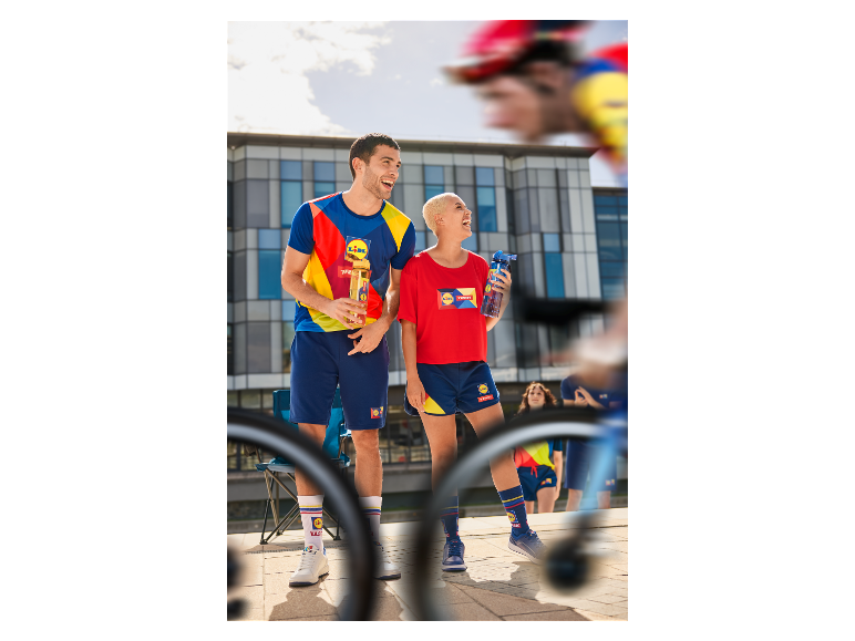 Twee lachende mensen in Lidl kleding en sokken buiten.