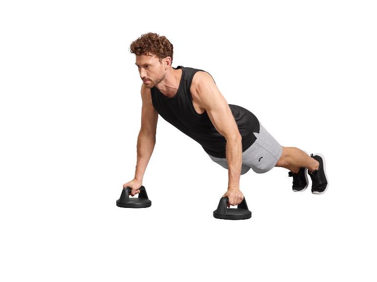 Man in zwart hemd en grijze korte broek doet push-ups met handvatten.