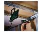 Hangende LED-werklamp en accuboormachine in gebruik op een bouwplaats.