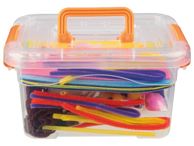 Transparante plastic doos gevuld met kleurrijke knutselbenodigdheden zoals pijpenragers en vilt.
