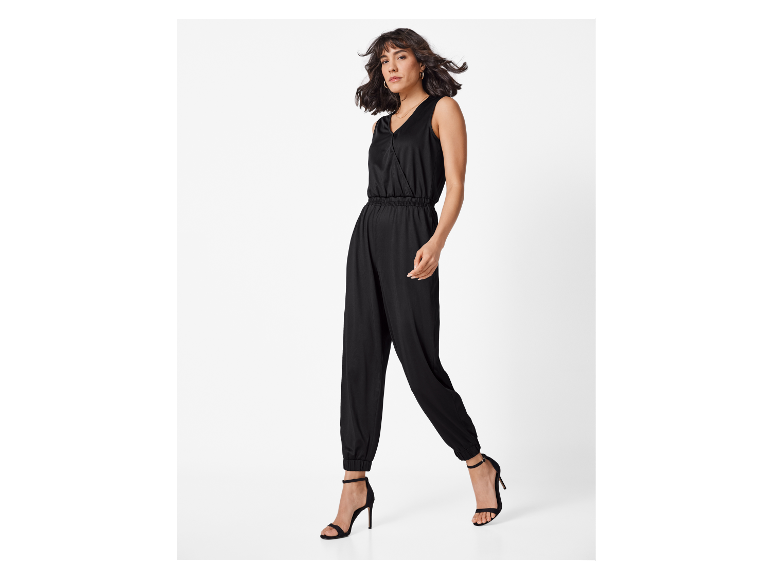 Een vrouw draagt een zwarte jumpsuit.