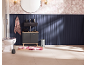 Badkamer met zwart wastafelmeubel, toilet, bloementapijt en marineblauwe lambrisering.