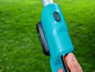 Een blauwe Gardena accu-trimmer met volle batterij.