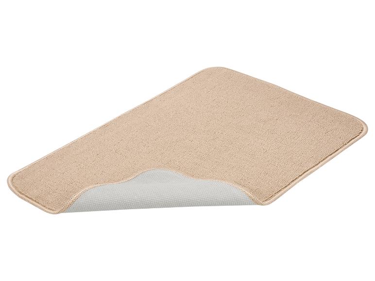 Beige antislipmat met opgevouwen hoek, die de onderkant toont.