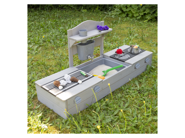 Houten kinderspeelkeuken met barbecue en zandbak in het gras.